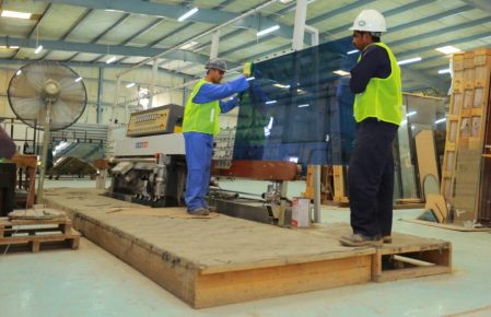 warehouse workers handling glass panel